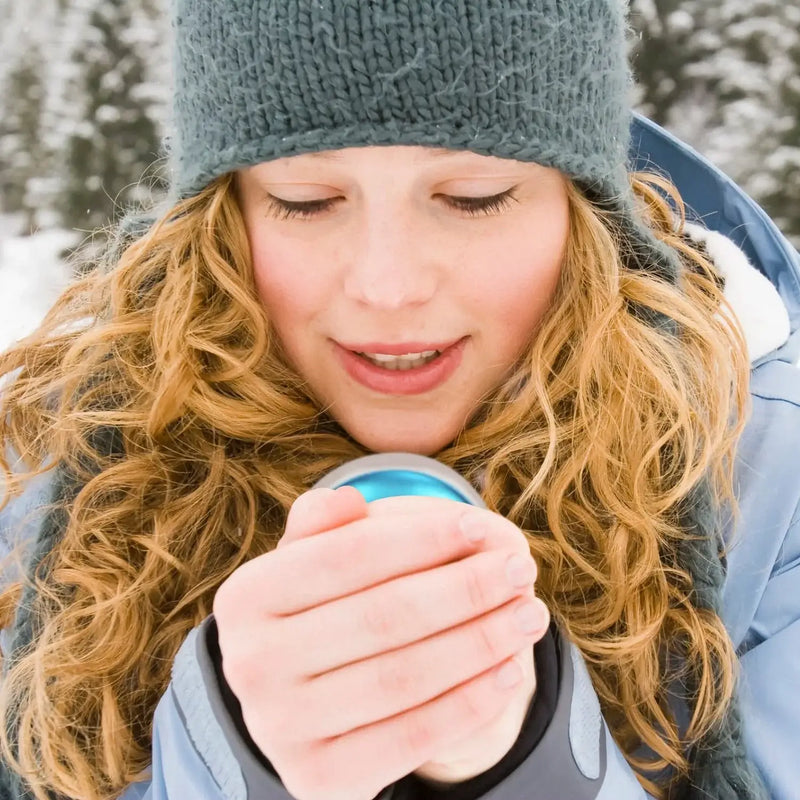 Rechargeable hand warmer in hand, demonstrating portability and usage