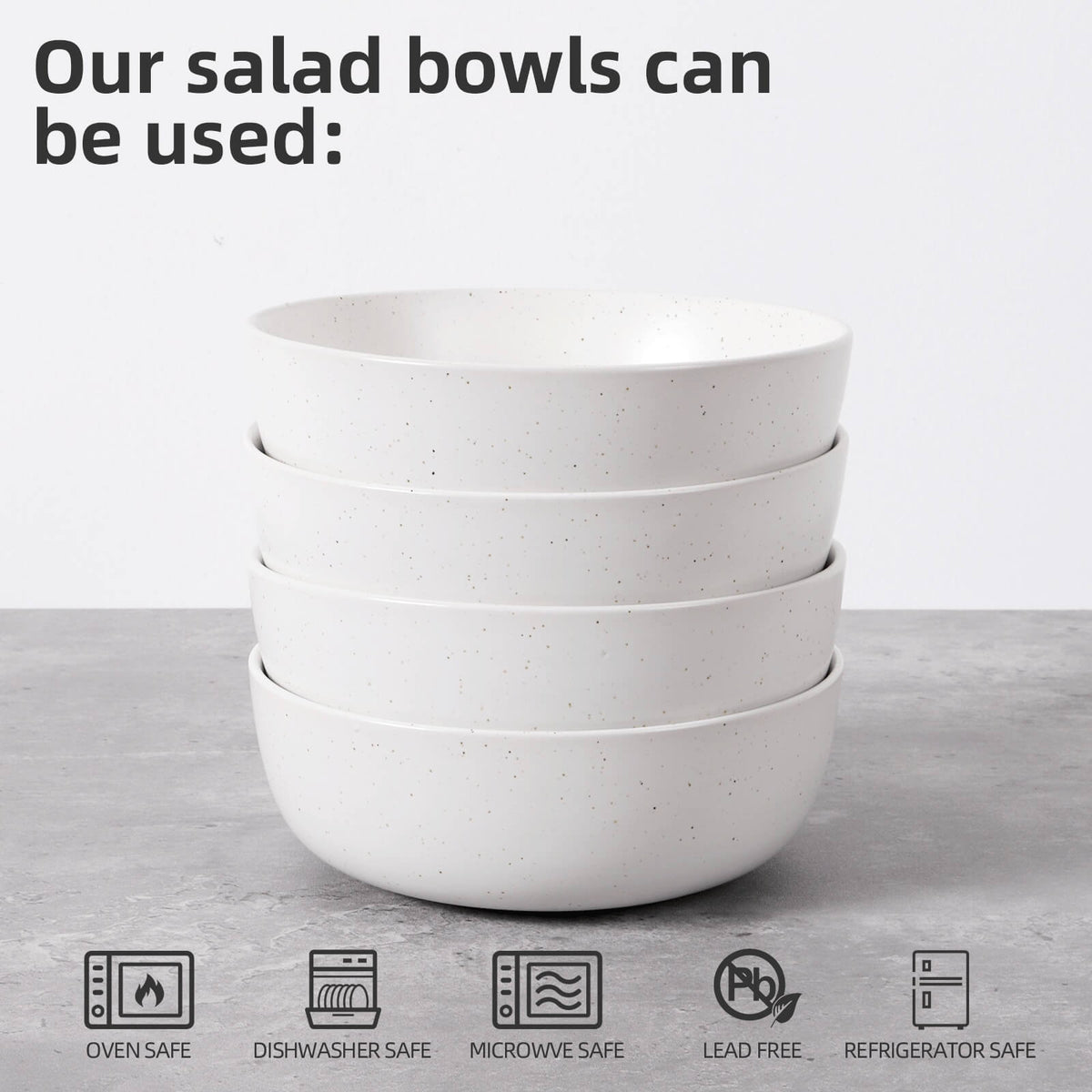 Four white speckled bowls stacked with oven safe, dishwasher safe, microwave safe, lead free and refrigerator safe icons below