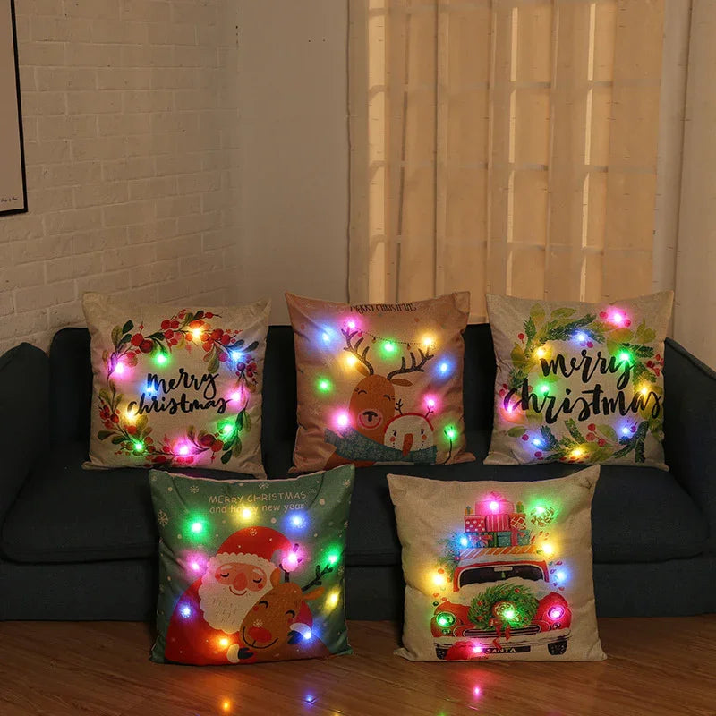 Five decorative Christmas pillows with colorful LED lights on a dark sofa in cozy living room