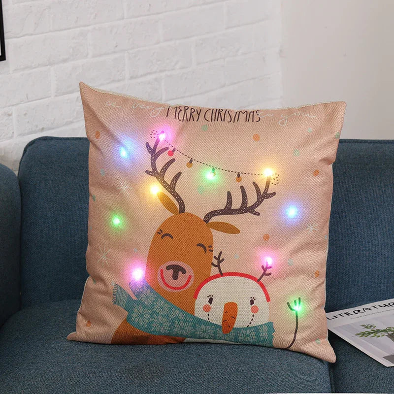 Christmas pillow with a smiling reindeer and snowman wearing a blue scarf, decorated with colorful LED lights