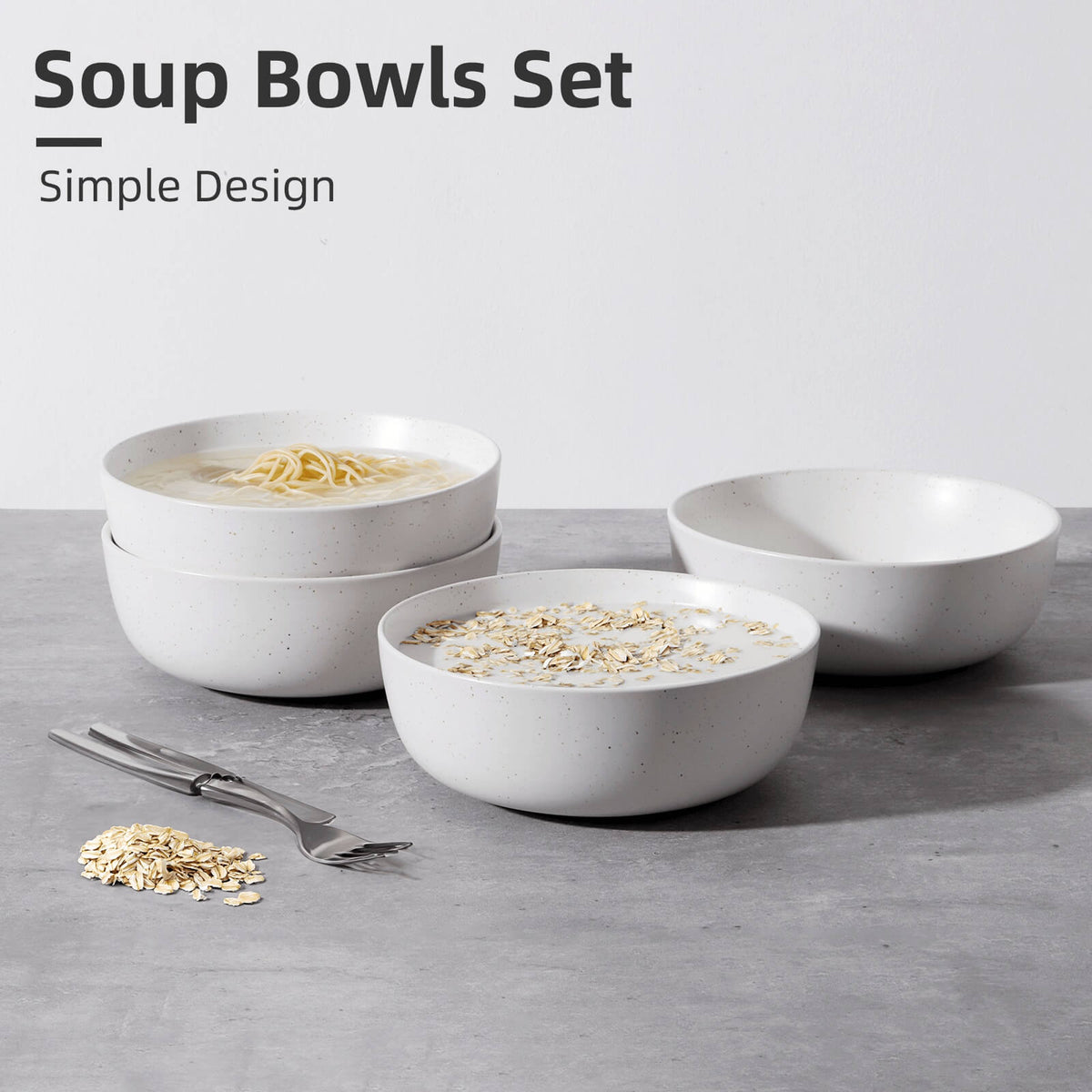 Four white speckled ceramic bowls on grey surface, two filled with noodle soup and oatmeal