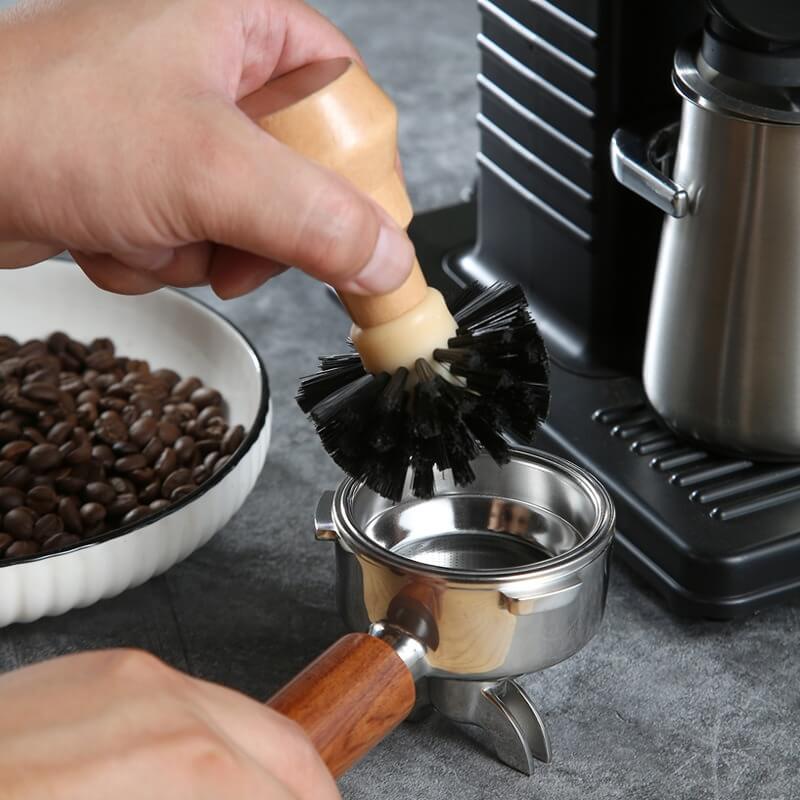 Coffee machine cleaning brush with natural wooden handle on wooden tray
