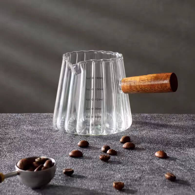 Close-up of ribbed borosilicate glass espresso cup with wooden handle