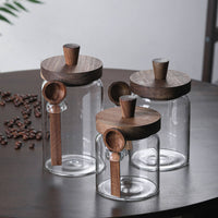 Empty glass coffee jars with walnut lids showing clear borosilicate glass