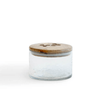 Leafy twig glass jar with wooden lid closed on white background