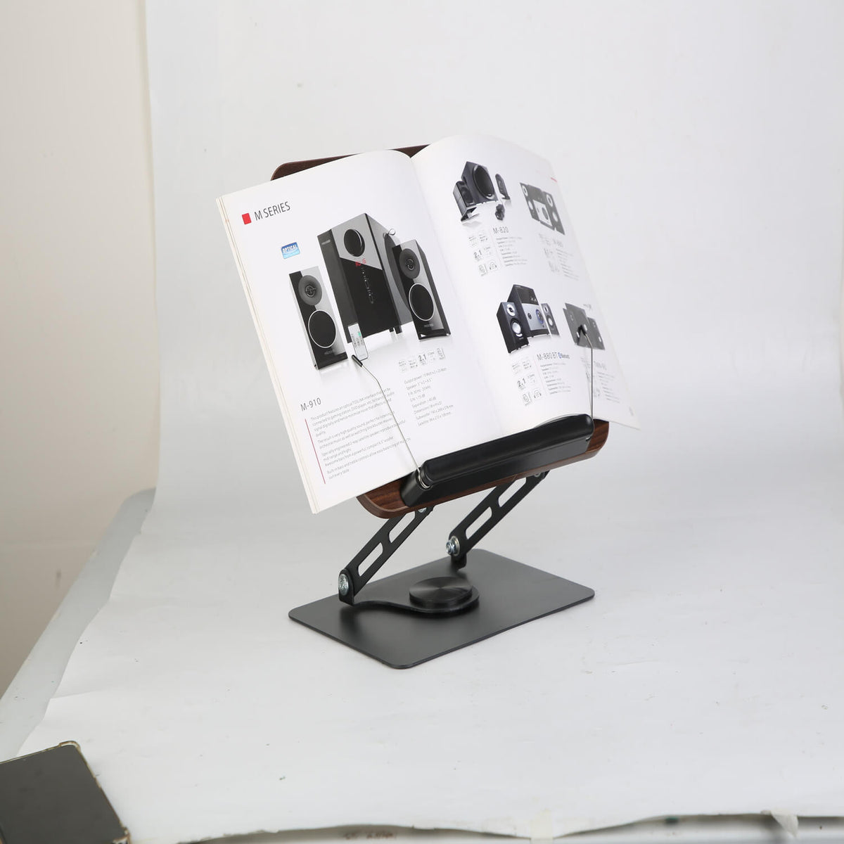 Wood book stand holding open magazine showing adjustable angle for reading